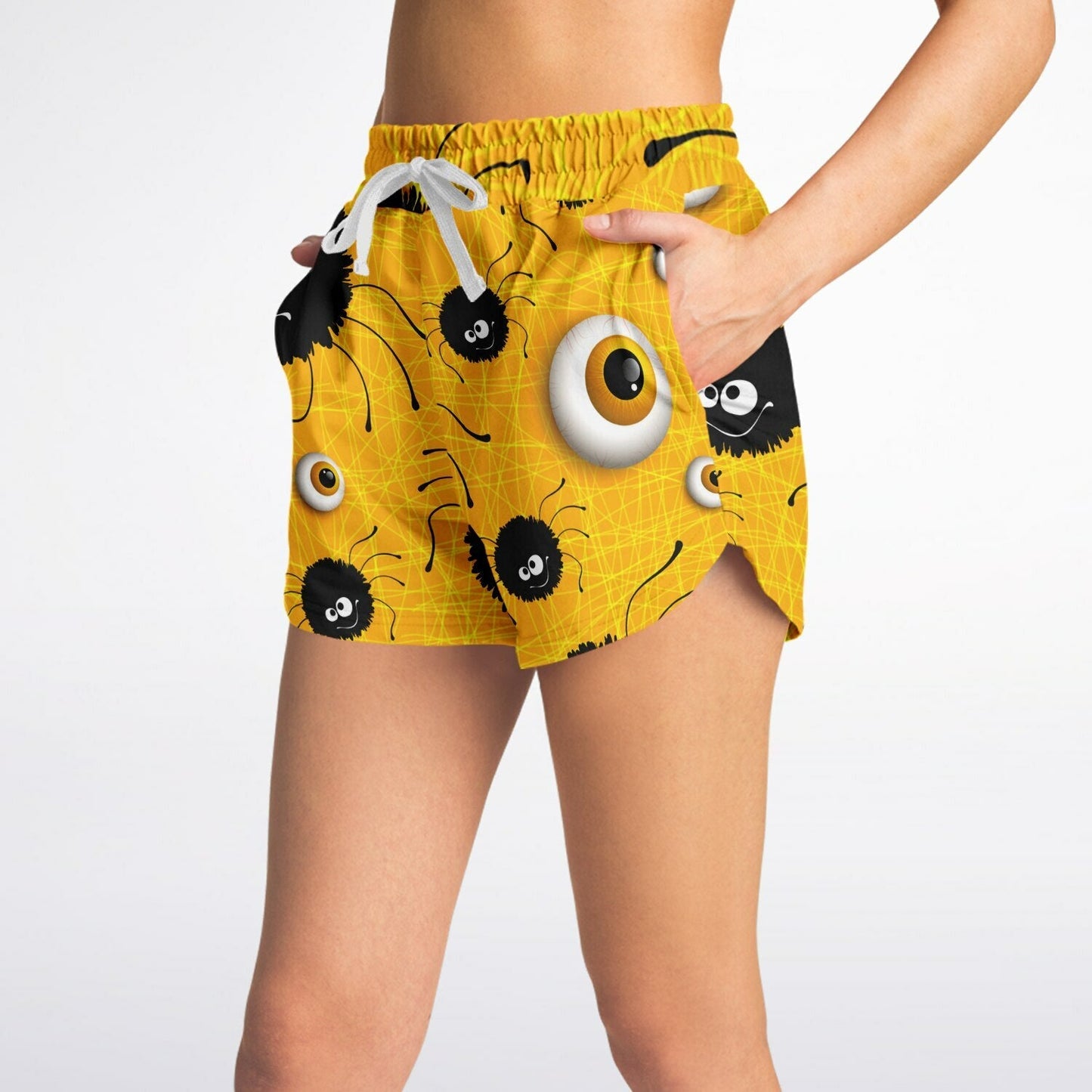 Side view of a woman wearing the yellow Halloween-themed shorts, with her hand in the side pocket.