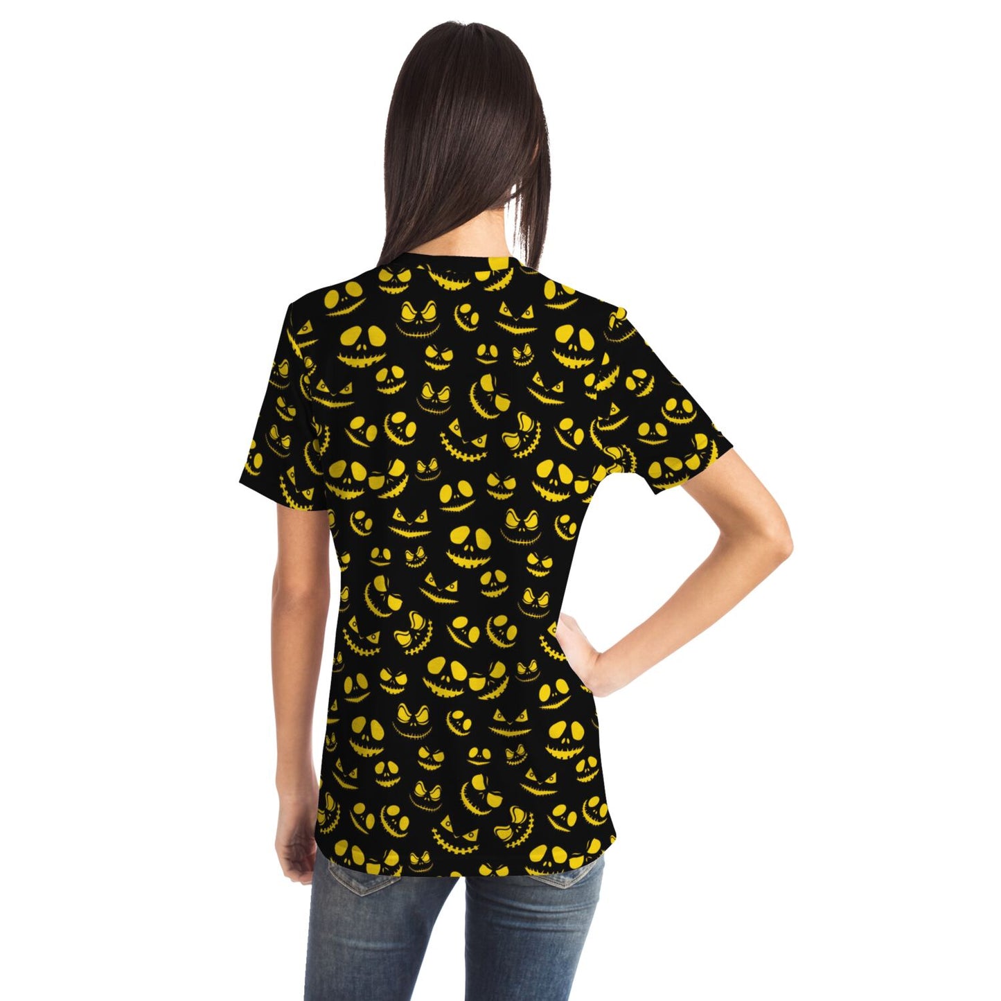 Back view of a woman wearing the t-shirt with an all-over pattern of glowing pumpkin faces.