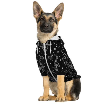 Dog sitting in black stellar hoodie with cosmic pattern and white zipper