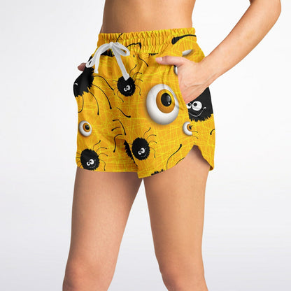  Side view of a woman wearing the yellow Halloween-themed shorts, with her hand in the side pocket.