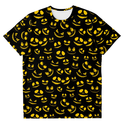 Front view of a black t-shirt laid flat, covered in a pattern of glowing yellow sinister pumpkin faces.