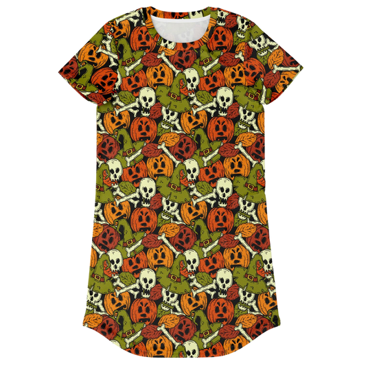 Front view of a t-shirt dress laid flat, covered in a repeating Halloween pattern of skulls and pumpkins.